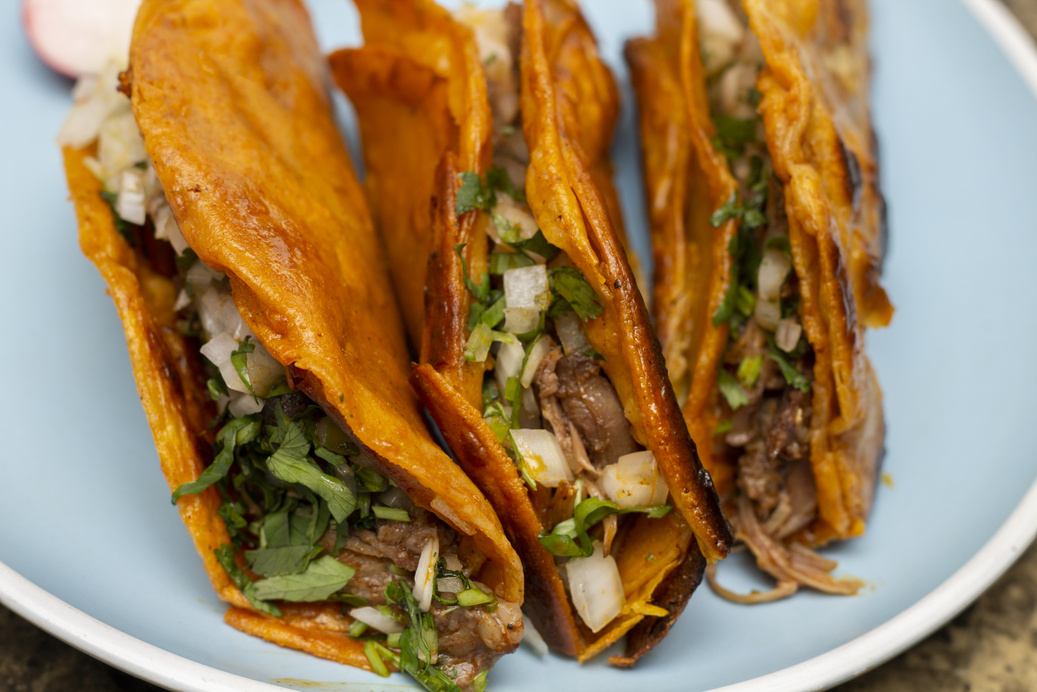 close up of 3 crispy birria tacos. Mexican food